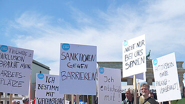 Menschen mit Plakaten auf einer Demonstration.