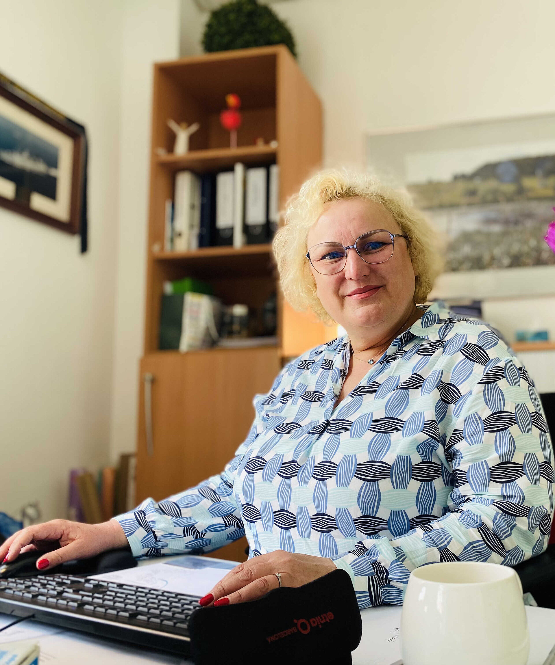 Eine Frau sitzt am Schreibtisch.