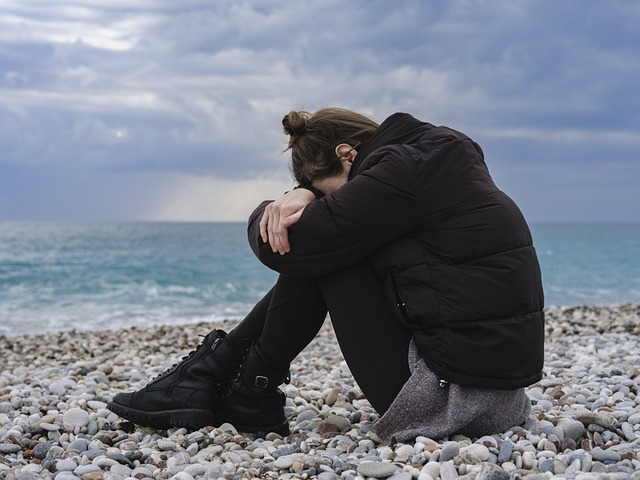 Eine traurige junge Frau am Strand.